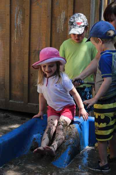girl going down a mud slide on a mud day